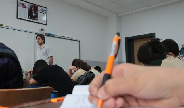 Görme engelli öğretmen, okulda öğrencilerin, yeşil sahada topun peşinden koşuyor
