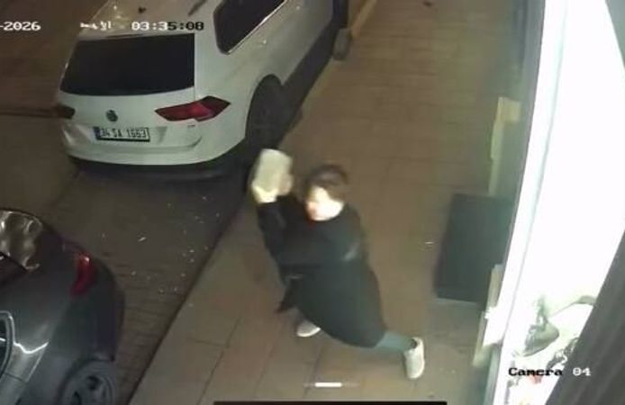 Kaldırım taşıyla iş yerinin camlarını kıran kadın kamerada